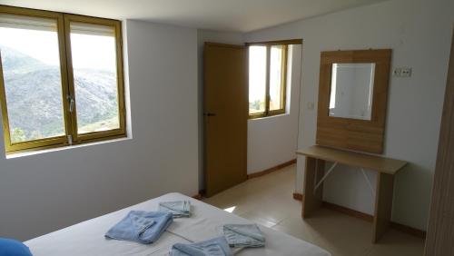 a bedroom with a bed with two blue towels on it at Gaitani Village in Léntas