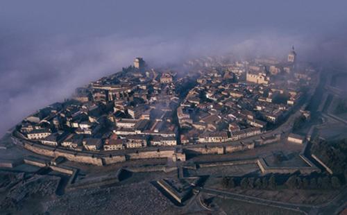an aerial view of a city in the clouds at Crisol Conde Rodrigo in Ciudad-Rodrigo