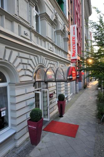 a building with a red rug in front of it at Mercure Hotel & Residenz Berlin Checkpoint Charlie in Berlin