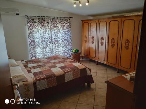 a bedroom with a bed and a wooden cabinet at Old style flat in Nebida