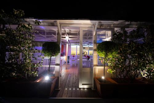 a night view of a room with plants and lights at QuodLibet in Rome