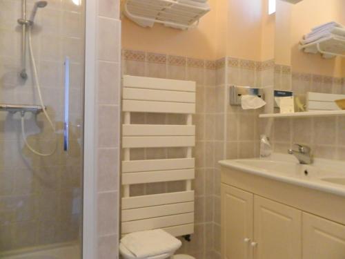 La salle de bains est pourvue d'une douche et d'un lavabo. dans l'établissement Hôtel La Caravelle, à Nyons