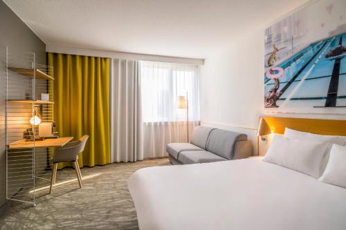 a hotel room with a bed and a couch at Hotel Novotel Evry Courcouronnes in Evry-Courcouronnes