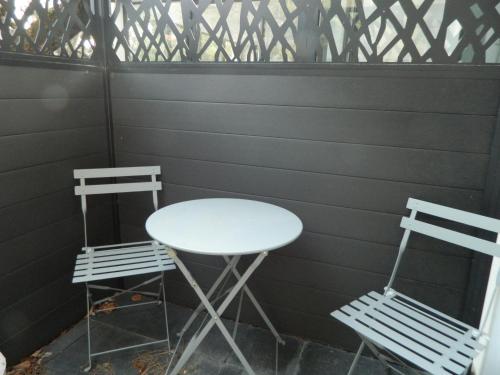 two chairs and a white table and a table and chairs at Hôtel La Caravelle in Nyons