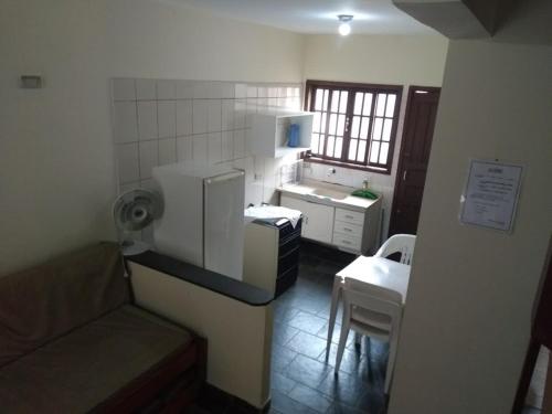 a small kitchen with a couch and a sink in a room at Pousada Atobá Bertioga in Bertioga