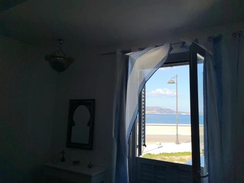 a room with a window with a view of the beach at Ajamola in Favignana