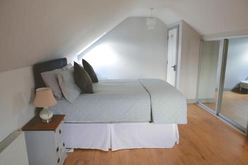 a bedroom with a large white bed with a table at Dolmen Cottage in Glencolumbkille