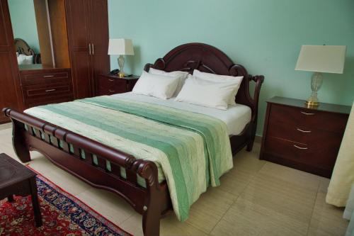 a bedroom with a bed with a green blanket at Lakepoint Villa in Entebbe