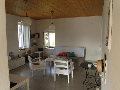 ein Wohnzimmer mit einem Tisch und einigen Stühlen in der Unterkunft Six-Bedroom House With Terrace Ionian Sea View in Neokhórion