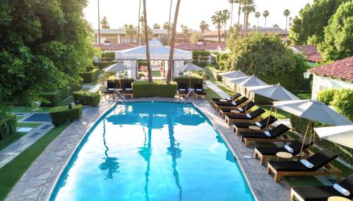 an overhead view of a pool with lounge chairs and umbrellas at Avalon Hotel & Bungalows Palm Springs, a Member of Design Hotels in Palm Springs