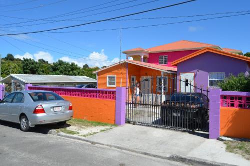 a colorful house with a car parked in front of it at Tequila Sunrise Antigua in Osbourn