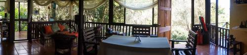 a room with a table and chairs on a balcony at Hospedaje La Naciente in Turrialba