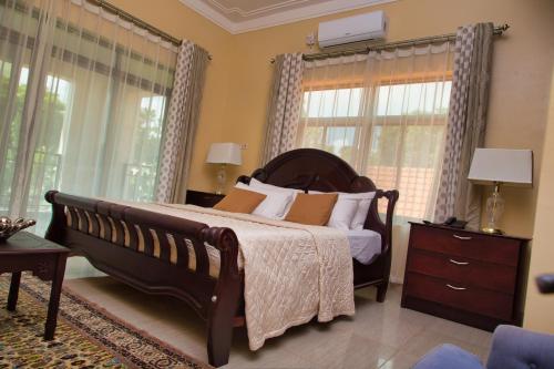 um quarto com uma cama grande e janelas em Lakepoint Villa em Entebbe