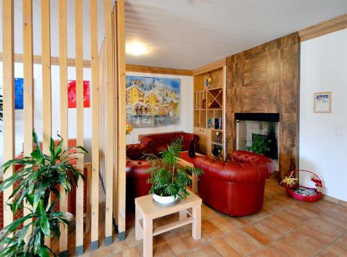 a living room with red leather furniture and plants at Hotel-Aparthotel San Bernardino in San Bernardino