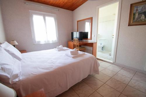 a bedroom with a large white bed and a bathroom at Hotel Villa Giada in Marina di Massa