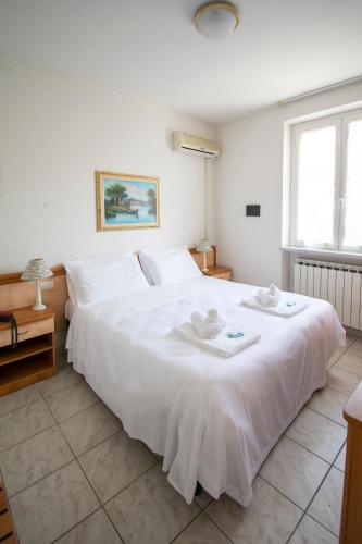 a bedroom with a large white bed with two towels on it at Hotel Villa Giada in Marina di Massa