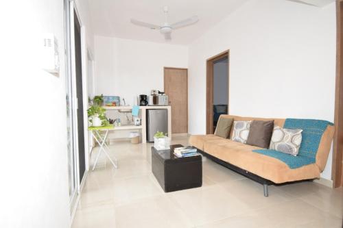 a living room with a couch and a table at Carlota Guest House in Cozumel