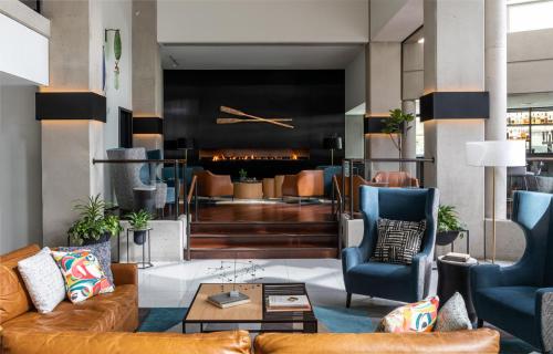 a lobby with couches and chairs and a fireplace at Hotel Murano in Tacoma