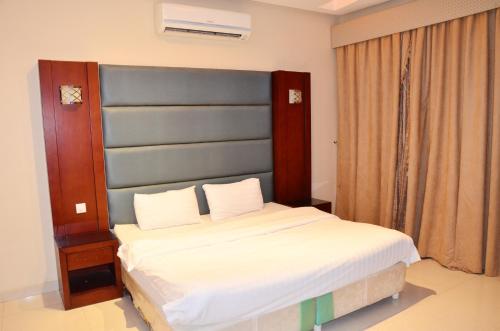 Silent Room 3 By Quiet Rooms في الرياض: غرفة نوم مع سرير كبير مع اللوح الأمامي الأزرق
