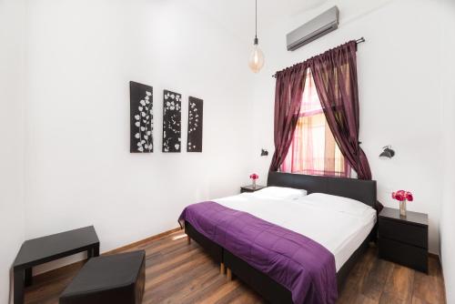a bedroom with a purple bed and a window at Karma Boutique Apartments in Budapest