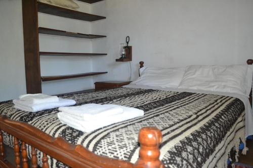 ein Schlafzimmer mit einem Bett, auf dem zwei Handtücher liegen in der Unterkunft Cabañas Los Relinchos in Capilla del Monte