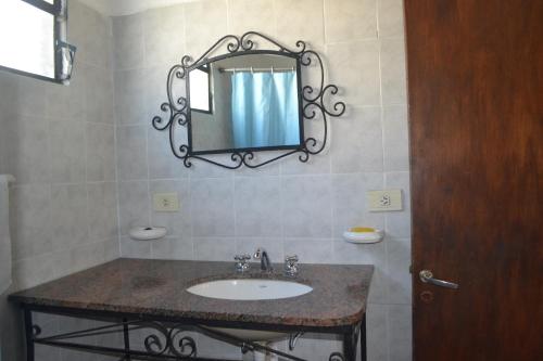 un bagno con un lavandino e uno specchio sul muro di Cabañas Los Relinchos a Capilla del Monte