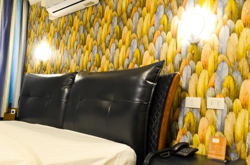 a bedroom with a couch and a wall with a wallpaper of birds at Hotel Boutique Holitel in Santiago