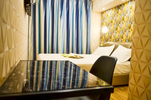 a hotel room with a bed and a glass table at Hotel Boutique Holitel in Santiago