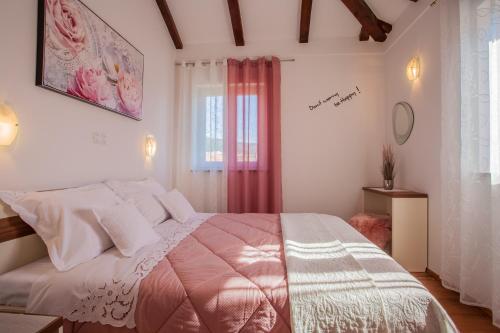 ein Schlafzimmer mit einem großen Bett und einem Fenster in der Unterkunft Apartman Madlen in Cres