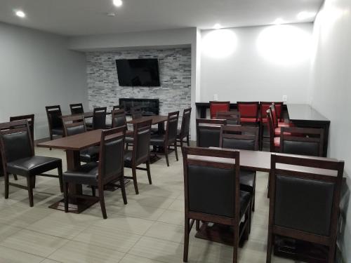 a dining room with tables and chairs and a fireplace at Super 8 by Wyndham Windsor/Dougall in Windsor
