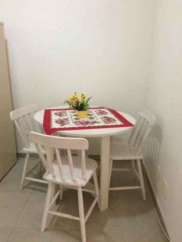a white table with chairs and a vase of flowers on it at Studio in Copa in Rio de Janeiro