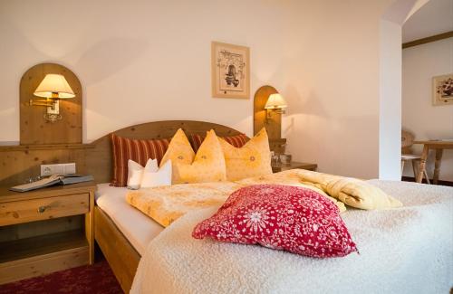 a bedroom with a bed with a red pillow on it at Almhof Roswitha in Hippach