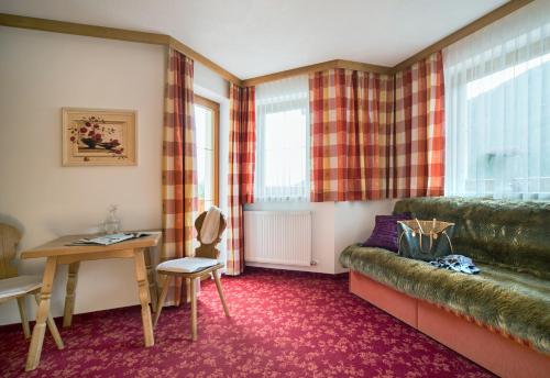 a living room with a couch and a table at Almhof Roswitha in Hippach