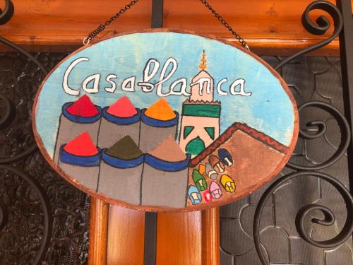 a sign on a gate with a picture of a cake at Campground Hostal La Bonanza Chez Kika in Piendamó