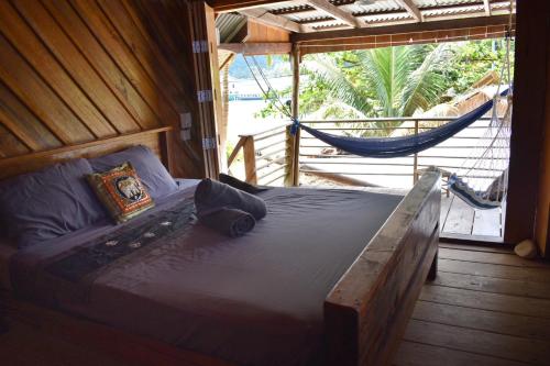 a bed with a hammock in a room with a window at Beach House Cambodia in Koh Rong Sanloem