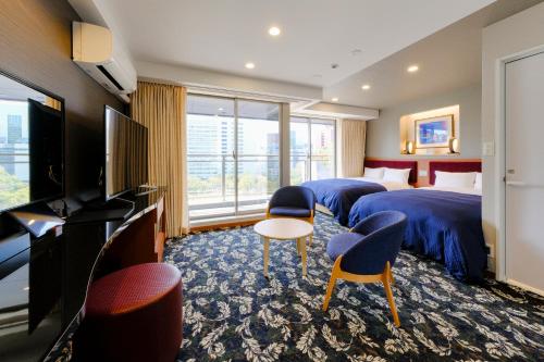 a hotel room with two beds and a flat screen tv at Hotel Grandolce HAKATA in Fukuoka