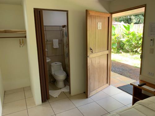 a bathroom with a toilet and an open door at Le Petit Hotel in Fortuna