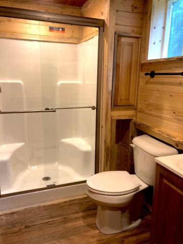 a bathroom with a toilet and a glass shower at Gateway Inn & Cabins in Ashford