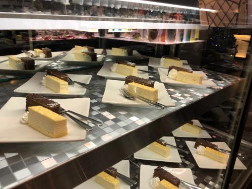 a display case filled with plates of cake and desserts at Restay Hiroshima (Adult Only) in Hiroshima