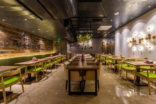 广州广州市邦泰国际公寓 (广州琶洲会展中心店)的有木桌和绿色椅子的餐厅