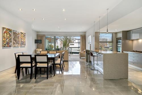 a kitchen and dining room with a table and chairs at City Sanctuary on Kilmore in Christchurch