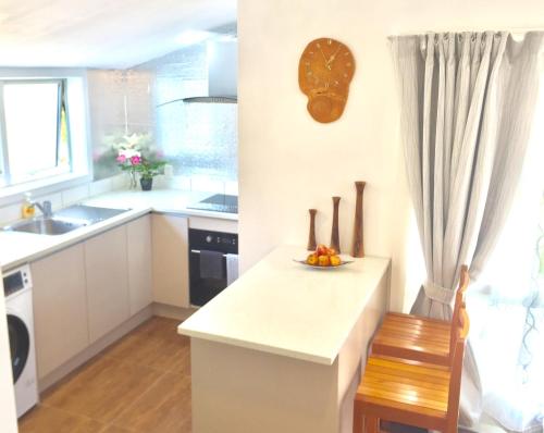 a kitchen with a sink and a counter with a bowl of fruit at G- HOUSE (CH-CH) in Christchurch