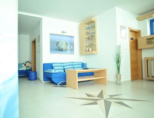 a living room with a blue couch and a table at Vila Polar in Štrbské Pleso