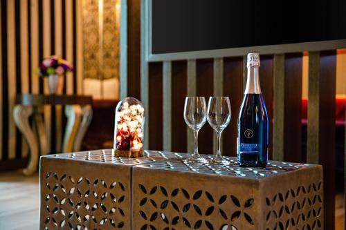 a bottle of wine and two wine glasses on a table at Affair motel Co.Ltd in Wuqi