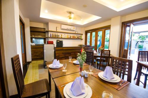 a dining room with a table and chairs and a kitchen at Khammon Lanna Resort Chiang Mai in Chiang Mai