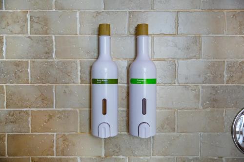 two bottles of wine hanging on a brick wall at Affair motel Co.Ltd in Wuqi