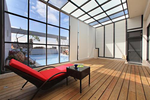 a living room with a red couch and large windows at Affair motel Co.Ltd in Wuqi