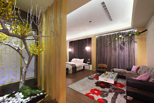 a living room with a couch and a tree in it at Affair motel Co.Ltd in Wuqi