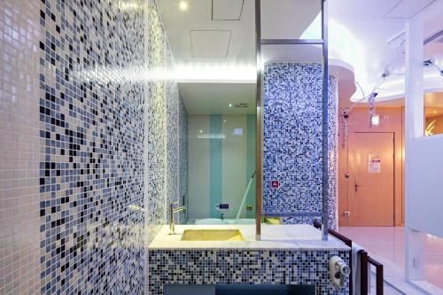 a bathroom with a shower with a sink and a mirror at Affair motel Co.Ltd in Wuqi