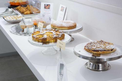 a display case with different types of cakes and pastries at Best Western Plus Royal Superga Hotel in Cuneo